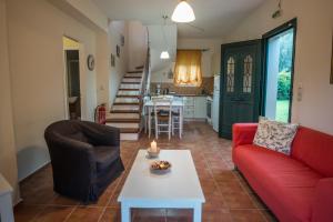 Una sala de estar con un sofá rojo y una mesa. en Vasilikos -Green Poros Village, en Mikros Gialos