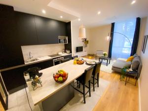 une cuisine et un salon avec une table et des chaises dans l'établissement Le Huppé, Hypercentre, proche Bastille, WIFI illimité & Netflix, à Grenoble