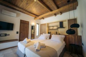 a bedroom with two beds with towels on them at Hide Out Villas in Mylopotas
