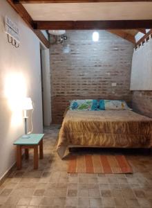 ein Schlafzimmer mit einem Bett und einem Tisch mit einer Lampe in der Unterkunft TENDERETE in Villa General Belgrano