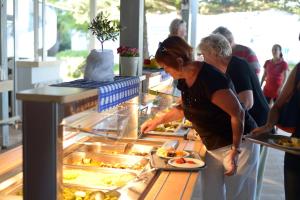 a woman is preparing food in a buffet at Kordistos Hotel in Kefalos