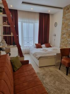 1 dormitorio con 1 cama y 1 sofá en una habitación en Milmari Apartman P38 en Kopaonik