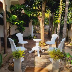 un grupo de sillas y mesas blancas en un patio en Malabar home stay en Jaffna