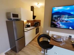 uma cozinha com um frigorífico e uma mesa com uma cadeira em -Neubau- 24 qm Studio-Apartment em Fulda