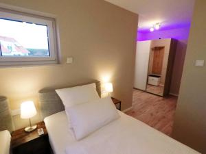 1 dormitorio con cama blanca y ventana en -Neubau- 24 qm Studio-Apartment en Fulda