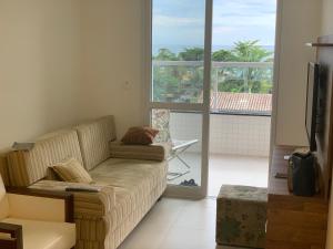 ein Wohnzimmer mit Couch und Balkon in der Unterkunft SOLAMAR - PRAIA Das TONINHAS in Ubatuba