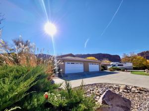 a house with a garage with the sun in the sky at Adventure Base Camp #381 in Moab