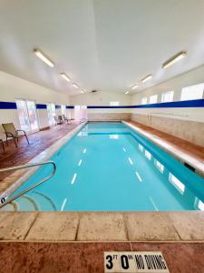 a swimming pool with blue water in a building at Adventure Base Camp #381 in Moab