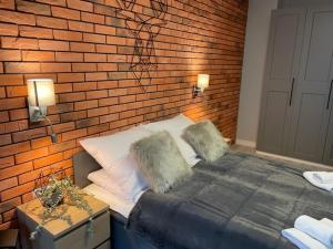 a bedroom with a brick wall and a bed at Apartament Silence Karpatia Resort Koral in Karpacz