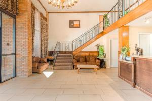 a living room with a staircase and a couch at OYO Hotel Jefferson TX Hwy 59 in Jefferson