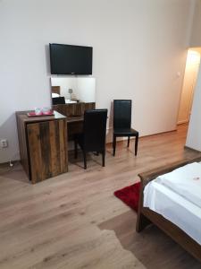 a bedroom with a bed and a desk and a television at Pensiunea Boema in Cluj-Napoca