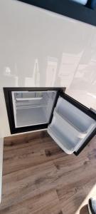 an empty refrigerator sitting on top of a wooden floor at Thea - MAGIC POINT in Mangalia