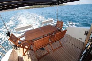 a wooden table and chairs on the deck of a boat at Thea - MAGIC POINT in Mangalia