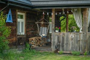 a porch of a log cabin with a hammock on it at Chata Latoś in Tocznabiel