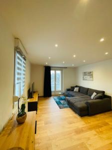 sala de estar con sofá y mesa en Appartement Les Tilleuls "3 étoiles", en Niederbronn-les-Bains