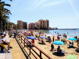 a crowd of people on a beach with umbrellas at Studio Arquitecto in Torrevieja