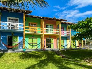 a colorful house with a palm tree in front of it at O Costão do Sol in Balneário Camboriú