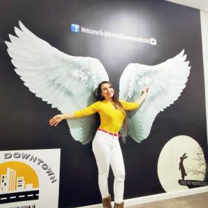 a woman with white wings standing in front of a wall at Madrid Downtown Hostel in Madrid