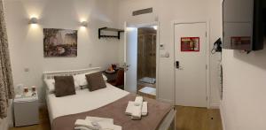 a bedroom with a white bed and a bathroom at City London Hotel in London