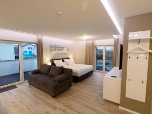 ein Schlafzimmer mit einem Bett und einem Sofa in einem Zimmer in der Unterkunft -Neubau- 42 qm Balkon-Apartment in Fulda
