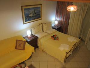 a hotel room with two beds and two lamps at Alessandro in Sidari