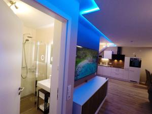 uma casa de banho com um tecto azul, um lavatório e um chuveiro. em -Neubau- 42 qm Balkon-Apartment em Fulda