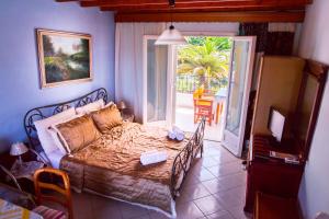 a bedroom with a bed and a door to a patio at Alessandro in Sidari