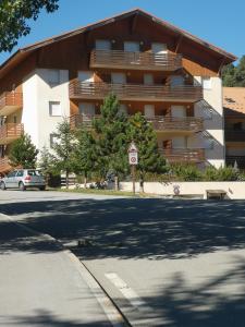 un gran edificio de apartamentos con una calle enfrente en Auron, 2 pièces meublé, coin montagne,6 couchages, en Auron