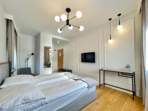 1 dormitorio con 1 cama blanca grande y escritorio en Pensjonat Winnica, en Toruń