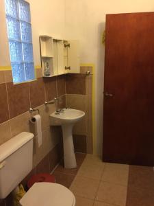 a bathroom with a sink and a toilet and a mirror at ALOJAMIENTO SERRANO in Villa Giardino +9 photos
