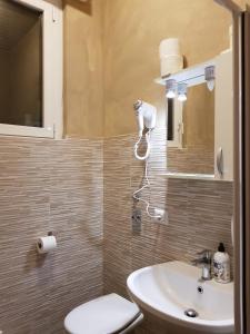 La salle de bains est pourvue de toilettes et d'un lavabo. dans l'établissement Gloria Hostel Milano, à Milan