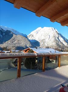 uma vista para uma montanha coberta de neve a partir de um alpendre em Zimmer bei Landhaus Mayr em Maurach