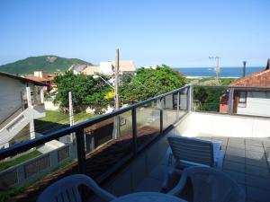 Un balcón con sillas y vistas al océano. en Santinho Hostel, en Florianópolis