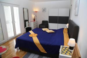 赫瓦爾的住宿－Apartment ELENA 40 m2 with beautiful wide sea views 3 stars，一间卧室配有一张蓝色的床,上面有黄色的带子