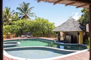una piscina con cenador junto a una casa en Pousada Oceano, en Caraíva