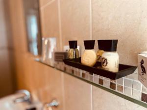 a shelf in a bathroom with three bottles on it at Le Bouchon Brasserie & Hotel in Maldon