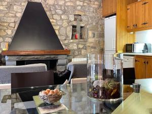 una mesa de cristal en una cocina con chimenea en El Vilarot. La casa de piedra en la naturaleza., en Girona