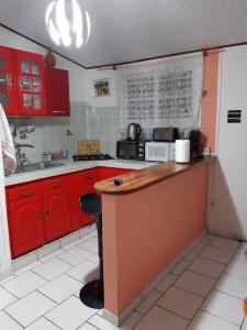 a kitchen with red cabinets and a counter top at Le petit nid vanillé in Sainte-Marie