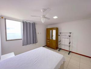 una camera da letto con un letto bianco e una finestra di Cobertura c/ vista para o mar e montanhas, churrasqueira, 4 quartos 2 Vg garagem a Guarapari Altre 41 foto