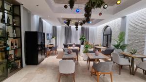 ARN Boutique Hotel في فوكشاني: مطعم فيه طاولات وكراسي في الغرفة