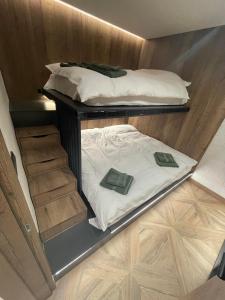 Dos literas en una habitación con suelo de madera. en Stella Bianca Apartman, en Jahorina