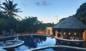 una piscina con cenador junto a una casa en Pousada Oceano, en Caraíva