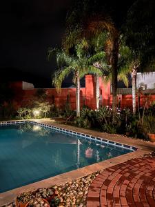 佛羅安那波里的住宿－Janela de Marcia Bed and Breakfast，棕榈树的夜间游泳池