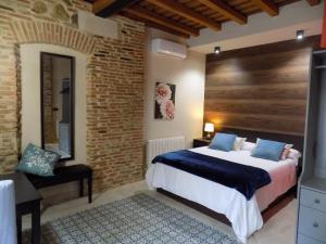 a bedroom with a bed and a brick wall at Apartamentos Suite Puerta del Jerte in Plasencia
