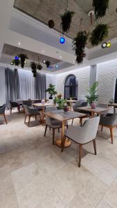 ein Restaurant mit Tischen und Stühlen in einem Raum in der Unterkunft ARN Boutique Hotel in Focşani