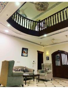 a living room with two couches and a staircase at Executive Galaxy Guest House Islamabad in Islamabad +38 photos