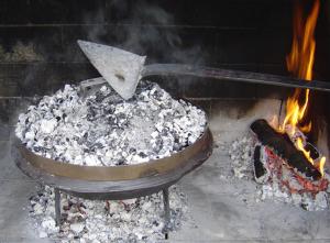 a pot with a spatula cooking on a fire at Apartment Duje & Josipa in Trogir