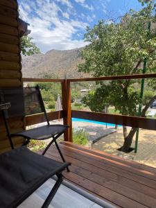 a chair on a deck with a view of a mountain at Refugio del Maipo Lodge in San José de Maipo