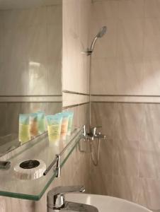 La salle de bains est pourvue d'un lavabo et d'un comptoir en verre. dans l'établissement Alhamra Horizons, à Al Hamra