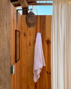 a bathroom with a towel hanging on a wooden wall at Porã Chacahua in Guayabas